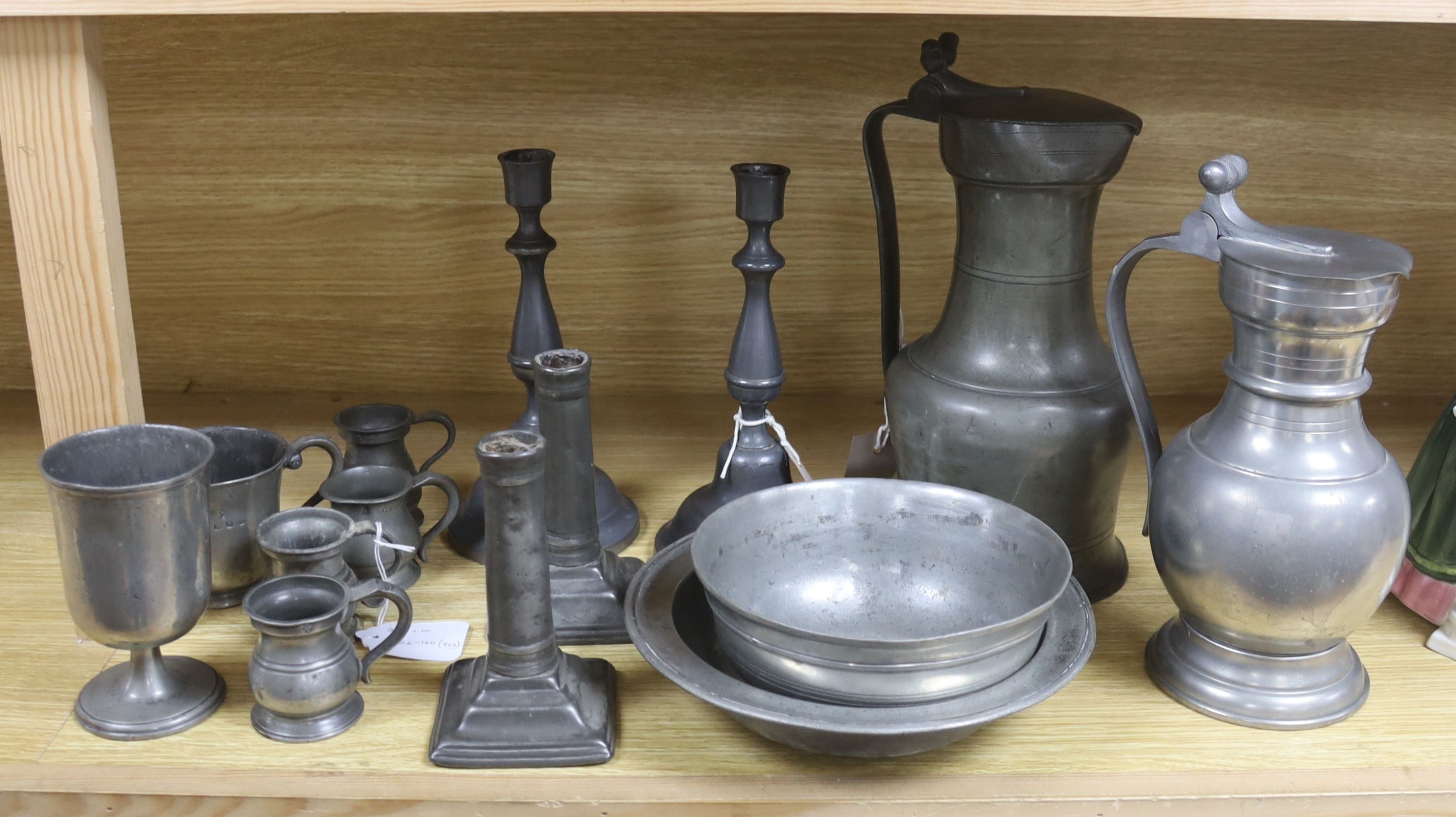 A French lidded pewter jug with double acorn thumbpiece, two pairs of pewter candlesticks and nine other items of pewter (14)